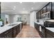 Open kitchen with stainless steel appliances, dark cabinets, and wood floors at 7809 E 114Th Ave, Temple Terrace, FL 33617