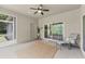 Relaxing lanai with a chair, rug, ceiling fan, and sliding glass doors leading to the interior at 7809 E 114Th Ave, Temple Terrace, FL 33617