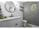 Modern bathroom with hexagonal gray tile feature wall, marble countertop vanity and round mirror at 851 3Rd Ave N, St Petersburg, FL 33701
