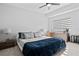 Modern bedroom featuring a king-size bed with blue blanket, ceiling fan and dresser with decorative items at 851 3Rd Ave N, St Petersburg, FL 33701
