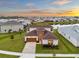 Stunning aerial view of a home in a lakeside community, showcasing the brick driveway and two-story design at 8612 Ivy Stark Blvd, Wesley Chapel, FL 33545