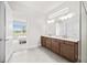 Well-lit bathroom with double vanity, and view into the adjacent bedroom space at 8612 Ivy Stark Blvd, Wesley Chapel, FL 33545