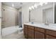 Bathroom with double vanity, tile flooring, and shower featuring tile surround at 8612 Ivy Stark Blvd, Wesley Chapel, FL 33545