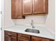 Butler's pantry featuring wood cabinets, white counters, and a stainless steel sink at 8612 Ivy Stark Blvd, Wesley Chapel, FL 33545
