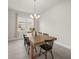 Dining room with modern chandelier, wood table and tile flooring at 8612 Ivy Stark Blvd, Wesley Chapel, FL 33545