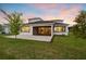 A patio with a screen overlooks a manicured lawn and a tranquil lake at 8612 Ivy Stark Blvd, Wesley Chapel, FL 33545