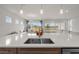 A kitchen island with a white countertop and sink offers a stunning view of the living room at 8612 Ivy Stark Blvd, Wesley Chapel, FL 33545
