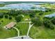 An aerial shot of a green park, a pond, playground and parking with the sky reflected in the water at 8749 Drummer Plank Dr, Wesley Chapel, FL 33545