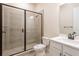 Modern bathroom featuring tiled shower with glass door, toilet, and vanity with black hardware at 8749 Drummer Plank Dr, Wesley Chapel, FL 33545