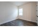 Simple bedroom features dark flooring, neutral walls, and a bright window at 8749 Drummer Plank Dr, Wesley Chapel, FL 33545