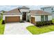 Inviting home featuring a two-car garage, brick accents, and manicured landscaping at 8749 Drummer Plank Dr, Wesley Chapel, FL 33545