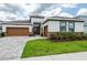 Inviting home featuring a two-car garage, brick accents, and manicured landscaping at 8749 Drummer Plank Dr, Wesley Chapel, FL 33545