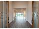 Bright and spacious foyer with elegant doors leading into open-concept living space and gorgeous floors at 8749 Drummer Plank Dr, Wesley Chapel, FL 33545