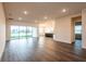 Large open-concept living room with hardwood floors and plenty of natural light from sliding glass doors at 8749 Drummer Plank Dr, Wesley Chapel, FL 33545