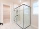 A large glass enclosed walk in shower with white marble and black hardware is spacious at 8749 Drummer Plank Dr, Wesley Chapel, FL 33545