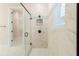 A large glass enclosed walk in shower with white marble and black hardware adds luxury at 8749 Drummer Plank Dr, Wesley Chapel, FL 33545