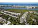 An aerial view of a townhouse community with a nearby pool, waterway, and Gulf beyond at 9660 Tara Cay Ct # 38, Seminole, FL 33776