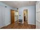 Bedroom with wood floors provides access to bathroom and additional room through open doorways at 9660 Tara Cay Ct # 38, Seminole, FL 33776