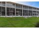 Exterior view of a screened in porch with multi-level condo and green grass at 9660 Tara Cay Ct # 38, Seminole, FL 33776