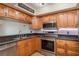 Modern kitchen with stainless steel appliances, wood cabinetry, and updated lighting at 9660 Tara Cay Ct # 38, Seminole, FL 33776
