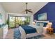 Bedroom with blue accent wall, features sliding glass doors to balcony, and is brightly lit at 9660 Tara Cay Ct # 38, Seminole, FL 33776