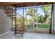 Relaxing screened porch with a spiral staircase and views of the backyard pond at 9660 Tara Cay Ct # 38, Seminole, FL 33776