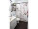 Bathroom featuring floral shower curtain, dark plank flooring, and a modern floating shelf at 1006 Harvest Moon Dr, Seffner, FL 33584