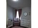 Bedroom with gray walls, mauve accents, a crib, changing table, and a comfortable rocking chair at 1006 Harvest Moon Dr, Seffner, FL 33584