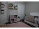 Well-decorated Bedroom with toy storage, book shelves, a pink rug, and a cozy crib at 1006 Harvest Moon Dr, Seffner, FL 33584