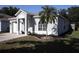 Well-maintained single-story home with gray paint, an arched window, a single-car garage and a landscaped front yard at 1006 Harvest Moon Dr, Seffner, FL 33584