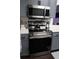 Stainless steel oven and microwave complement the gray cabinetry and the white quartz countertops in this modern kitchen at 1006 Harvest Moon Dr, Seffner, FL 33584