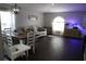 Open concept dining and living area featuring hardwood floors, white couch, and a large arched window for natural light at 1006 Harvest Moon Dr, Seffner, FL 33584