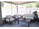 A screened patio with white cushioned furniture and a table at 1006 Harvest Moon Dr, Seffner, FL 33584