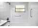 Bright bathroom featuring a tub with shower and safety handles at 10215 N 23Rd St, Tampa, FL 33612