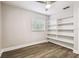 Bedroom showing window with blinds, shelving and light hardwood floors at 10215 N 23Rd St, Tampa, FL 33612
