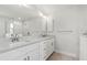 Elegant bathroom features double vanity, white cabinets, and a glass-enclosed shower for a luxurious experience at 10237 Deerwood Ave, Englewood, FL 34224