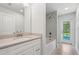 Bright bathroom featuring a vanity, tub, and natural light, creating a relaxing space at 10237 Deerwood Ave, Englewood, FL 34224