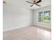 Bright bedroom featuring a ceiling fan, tile floors, and a large window with natural light at 10237 Deerwood Ave, Englewood, FL 34224