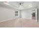 Spacious bedroom features a tray ceiling with ceiling fan and natural light, leading to the kitchen at 10237 Deerwood Ave, Englewood, FL 34224