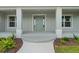 Close up of the front door with sidelights, columns, and manicured landscaping at 10237 Deerwood Ave, Englewood, FL 34224