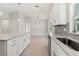 Bright kitchen with modern white cabinets, an island, and stainless steel appliances at 10237 Deerwood Ave, Englewood, FL 34224