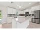 Bright, modern kitchen features white cabinets, stainless steel appliances, and a large center island, perfect for cooking at 10237 Deerwood Ave, Englewood, FL 34224