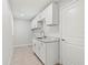 Bright laundry room with sink, white cabinets, and granite countertops at 10237 Deerwood Ave, Englewood, FL 34224