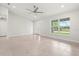 Bright living room with large window, ceiling fan, neutral paint, and tiled floors at 10237 Deerwood Ave, Englewood, FL 34224