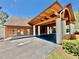 View of the building exterior with a distinctive porte-cochere and ample parking at 10636 Millriver Dr, New Port Richey, FL 34654