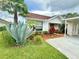 Attractive single-story home showcasing lush landscaping, including a large agave plant, and a convenient carport at 10636 Millriver Dr, New Port Richey, FL 34654