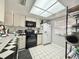 Efficient kitchen with white cabinets, black appliances, and checkered backsplash at 10636 Millriver Dr, New Port Richey, FL 34654