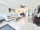 Cozy living room featuring wood floors, comfortable seating, and a ceiling fan at 10636 Millriver Dr, New Port Richey, FL 34654