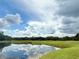 Scenic view of pond reflecting the blue sky and white clouds at 10636 Millriver Dr, New Port Richey, FL 34654