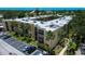 A view of the exterior of the condo building with palm trees, balconies and green landscaping at 11485 Oakhurst Rd # 310, Largo, FL 33771